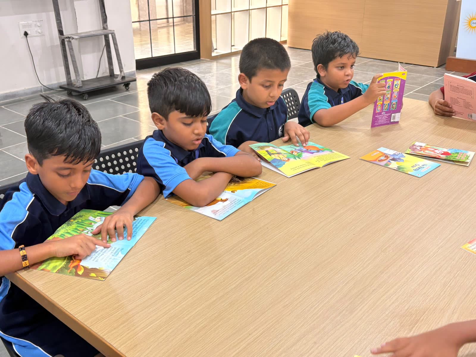Students reading picture books together at a library table