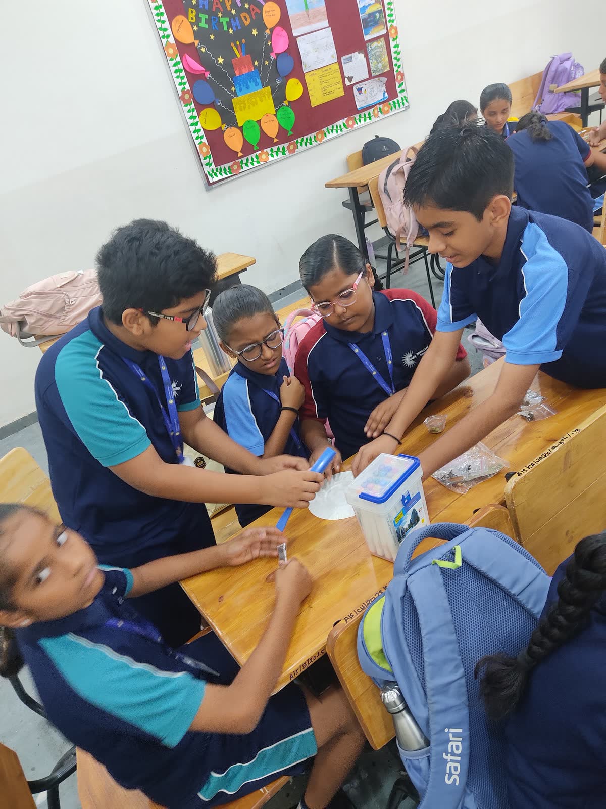 AARK students leaning over a desk together, working on a science activity