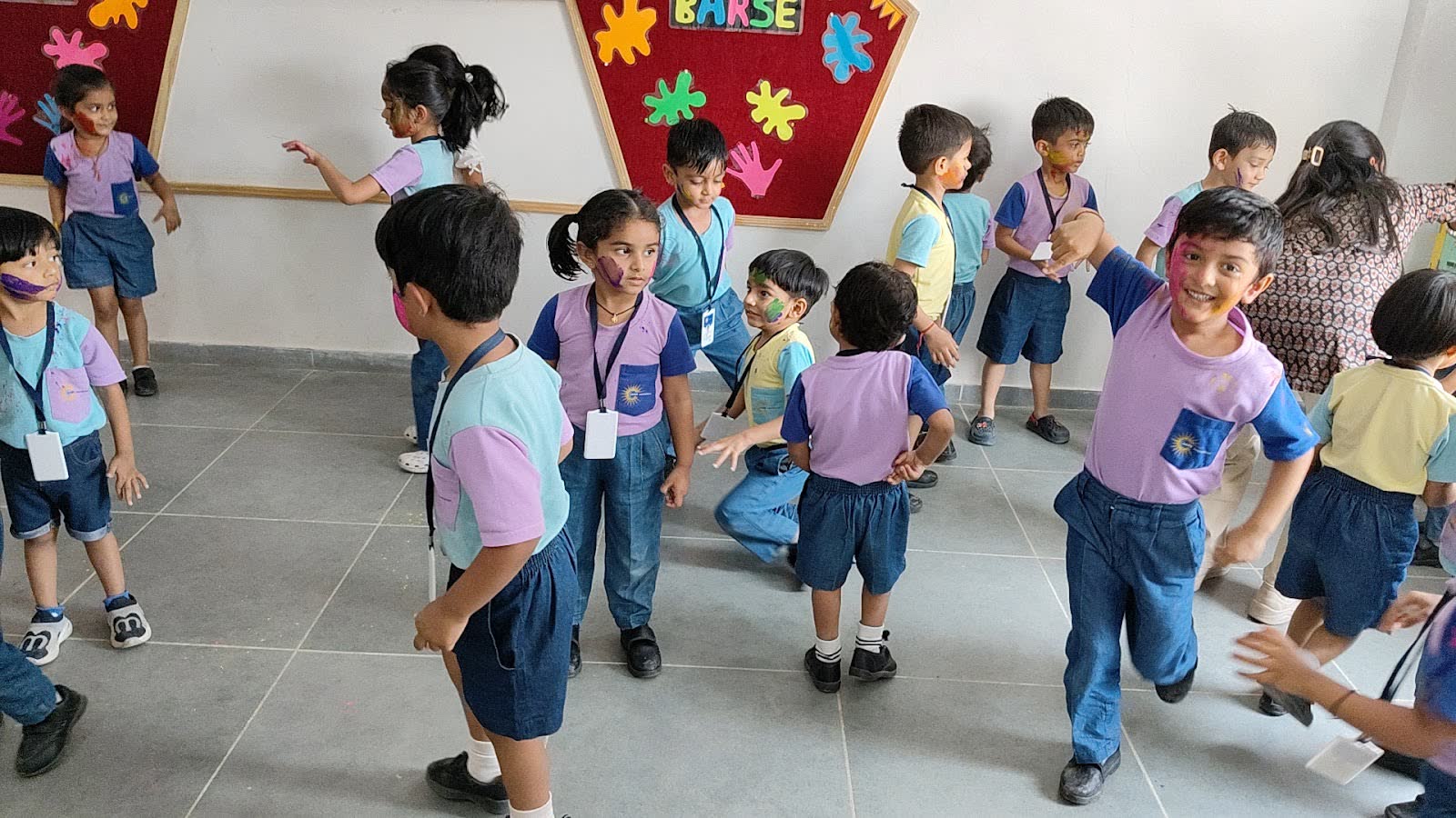 Children running and playing together indoors on Holi