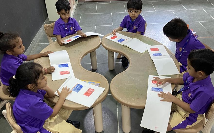 AARK Nursery children in purple uniforms working on picture cards at small tables