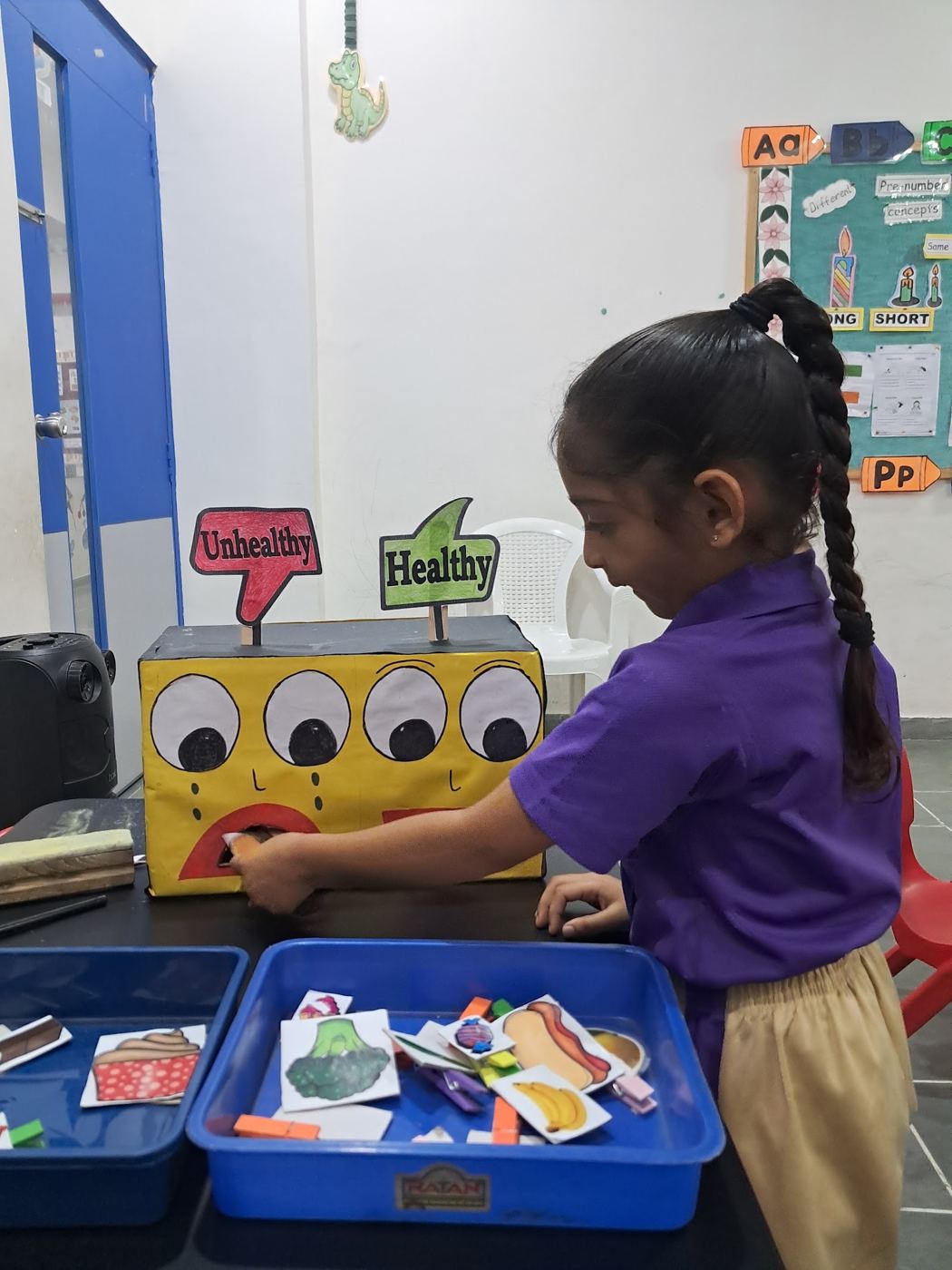 A young AARK student sorting cards at an activity box