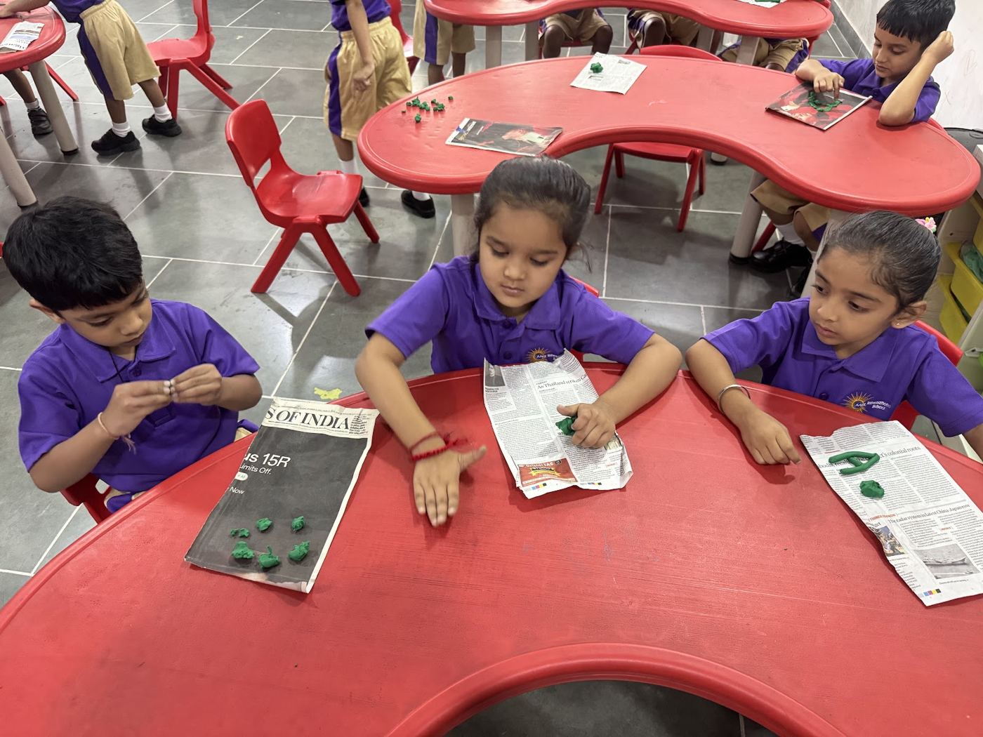 Young children modelling with clay at a classroom table
