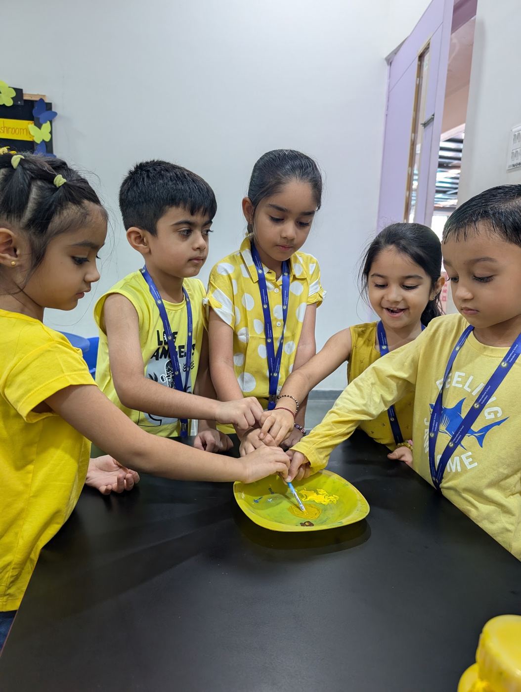 Children in yellow trying a hands-on science activity together